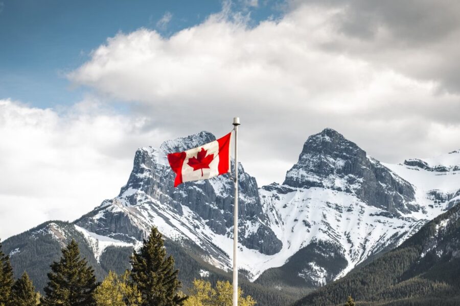 canadian flag flying over the rocky mountains